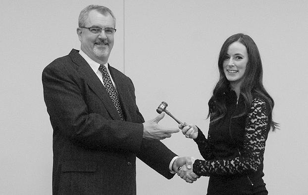 Alexis Young passes the Chamber gavel to Chris Garber in January 2015.